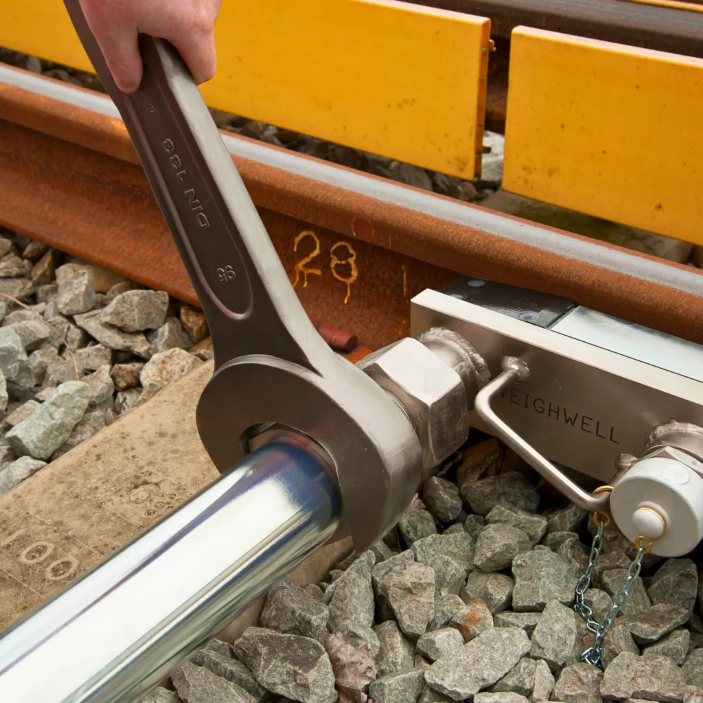 Sistema portátil de pesaje ferroviario ajustándose con una llave
